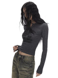 Close-up of a woman's torso wearing a dark grey long-sleeve graphic print cropped top.