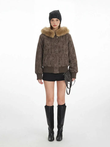 Woman wearing a brown bomber jacket with a star pattern and fur collar
