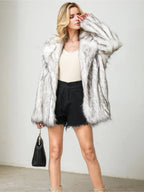 Close-up of a woman's face and shoulders wearing a white and grey faux fur jacket