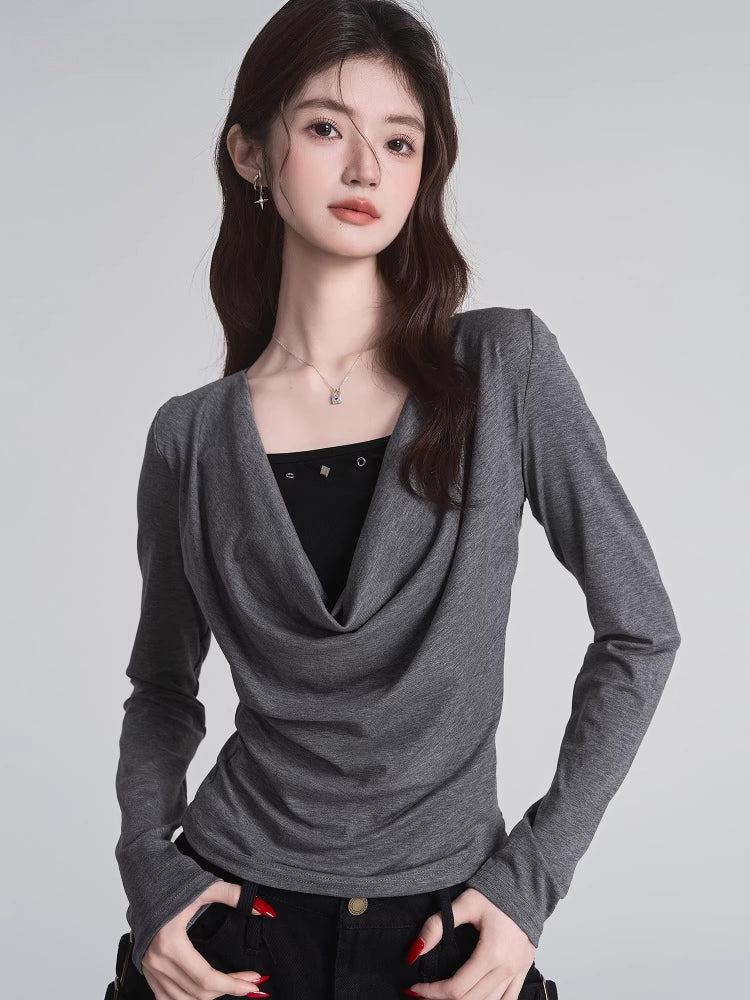 Close-up of woman in grey draped cowl neck long sleeve top