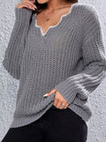 Detail of the grey knit sweater's texture and neckline.
