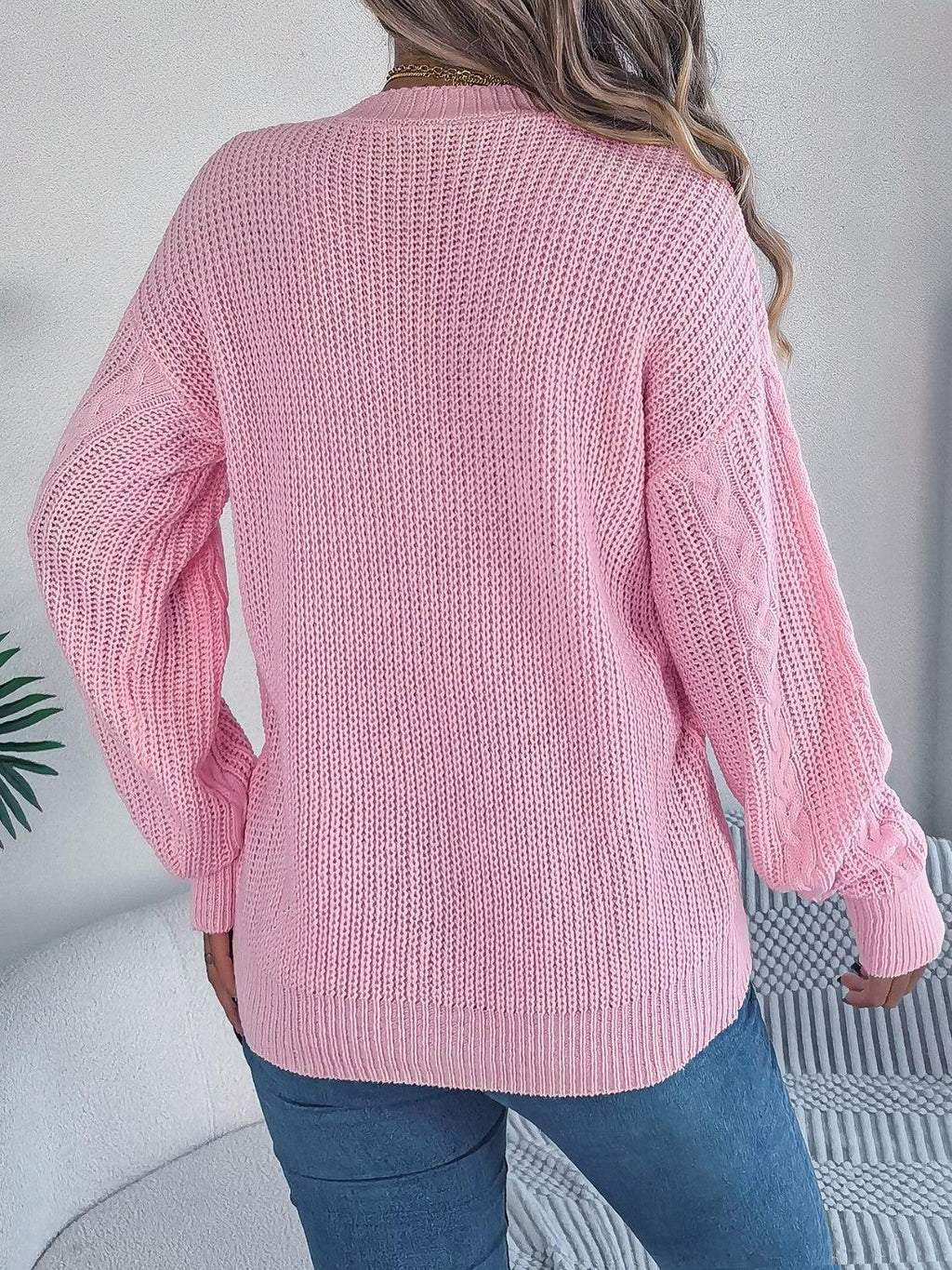 Back view of a woman in a pink cable knit cardigan