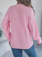 Back view of a woman in a pink cable knit cardigan