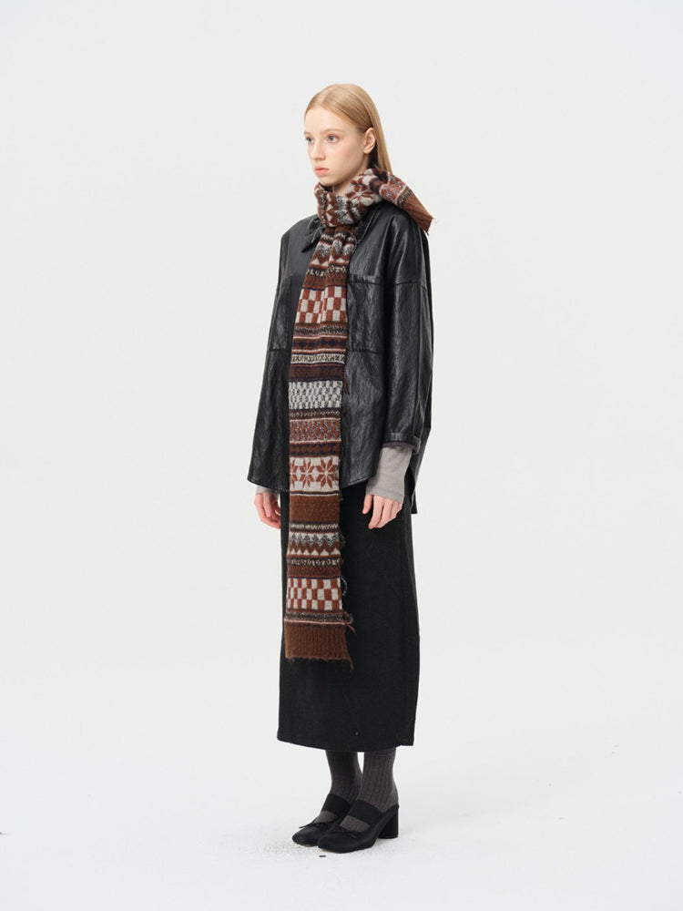 Woman wearing a black jacket and long skirt with a patterned scarf