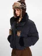 Side view of a woman in a cropped plaid puffer jacket, showcasing the texture and collar detail.
