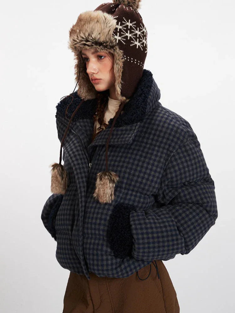 Side view of a woman in a cropped plaid puffer jacket, showcasing the texture and collar detail.