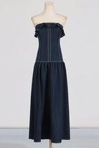Mannequin displaying the front of a navy blue denim maxi dress with a ruffled strapless neckline and peplum waist