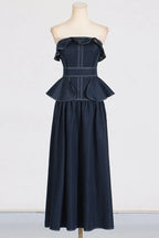 Mannequin displaying a navy blue denim maxi dress with a ruffled strapless neckline and peplum waist