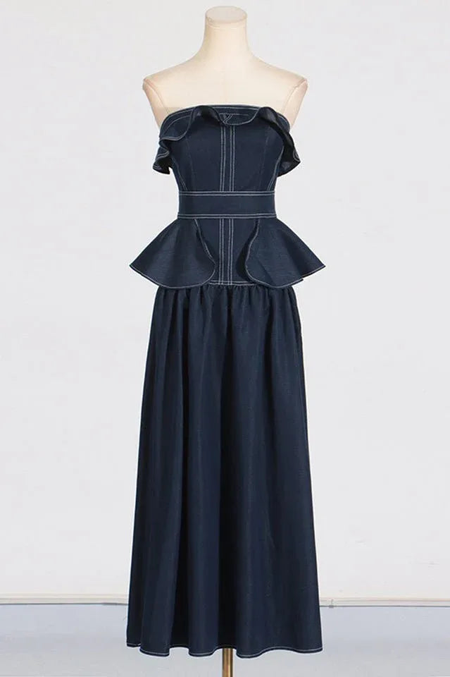 Mannequin displaying a navy blue denim maxi dress with a ruffled strapless neckline and peplum waist