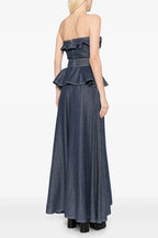 Back view of a navy blue denim maxi dress with a ruffled strapless neckline and peplum waist
