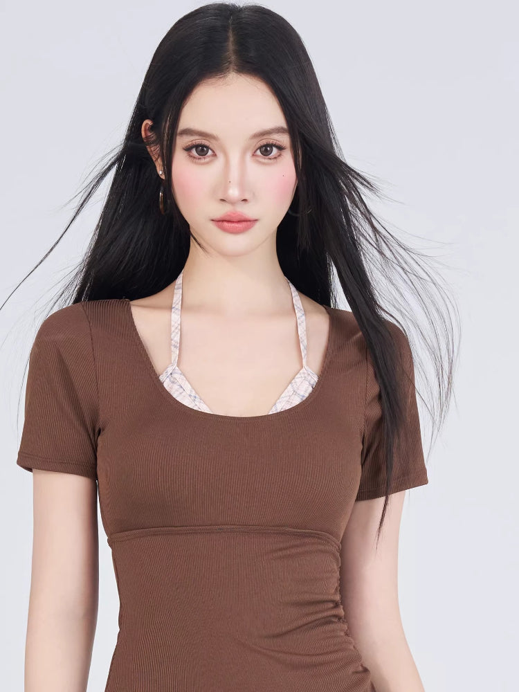 Close-up of the woman's face and the top of the brown swimsuit with plaid underlayer