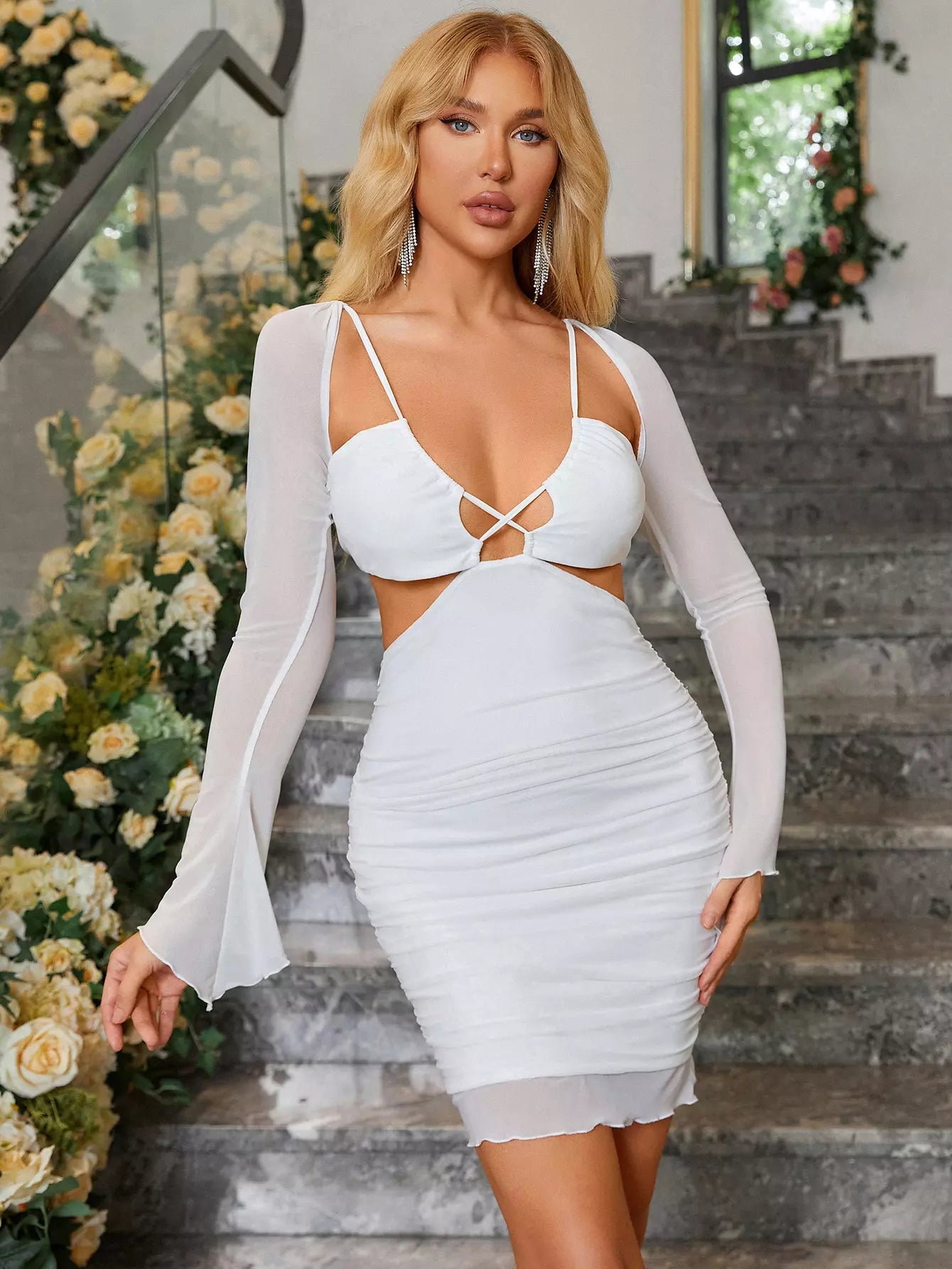 Woman wearing a white double layer mesh cut out dress with long bell sleeves