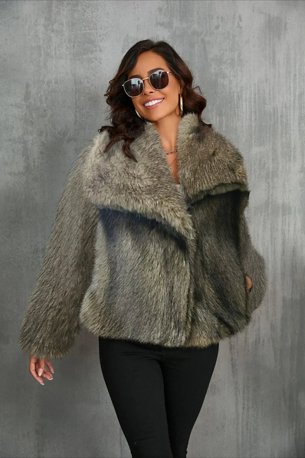 Woman smiling in a grey faux fur jacket with a wide collar.