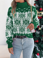 Woman wearing a green and white snowflake pattern turtleneck sweater and holding a purse, front view.