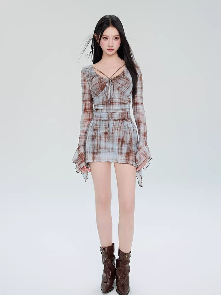 Full-body shot of a woman in a plaid mini dress with boots