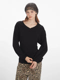 Full body front view of a model wearing a black V-neck long-sleeve top and leopard print wide-leg pants.