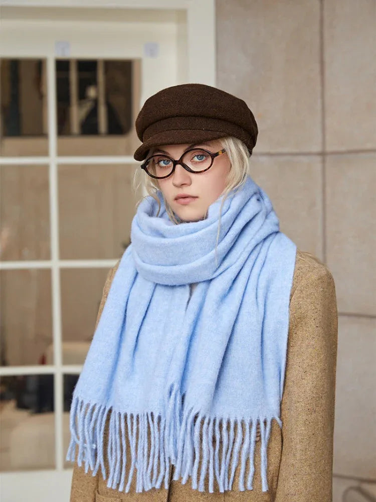 woman in a light blue scarf and brown jacket