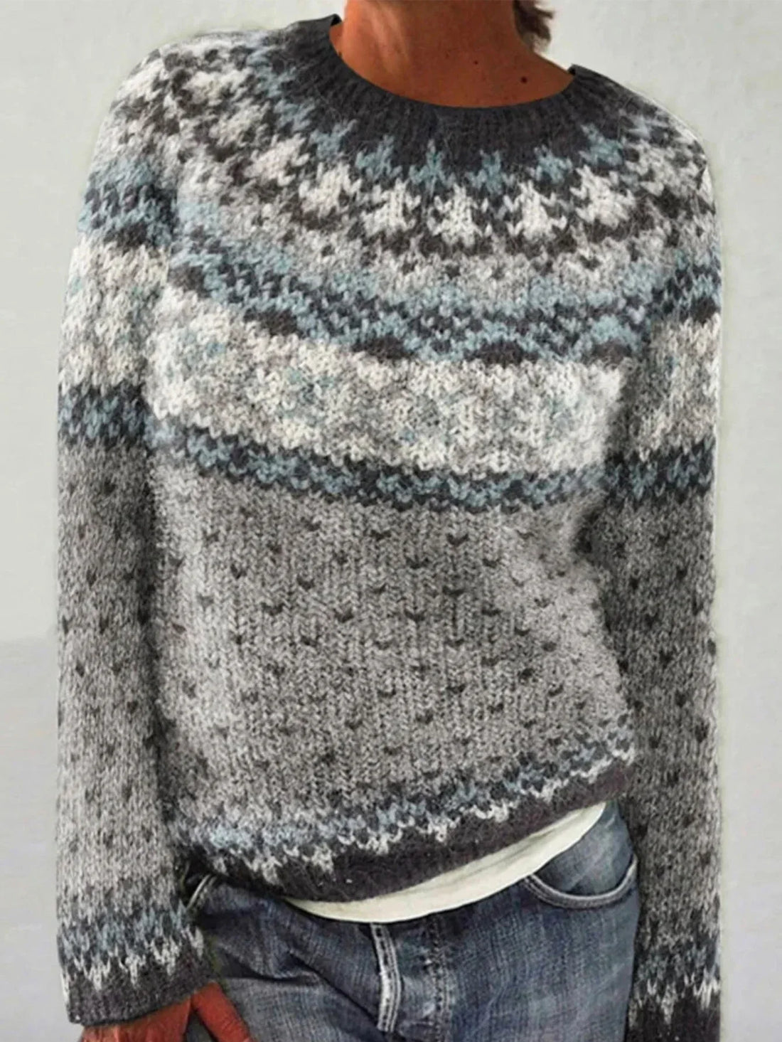 Woman wearing a grey and blue Fair Isle knit sweater with jeans