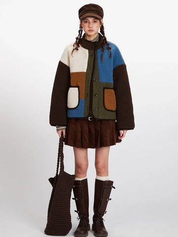 Woman wearing a color-block fleece jacket with brown pants and boots