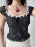 Close-up of the ruched bust and ribbon tie detail on the polka dot top