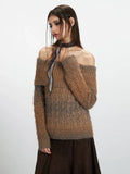 Model posing in a brown and grey gradient off-the-shoulder knit sweater.