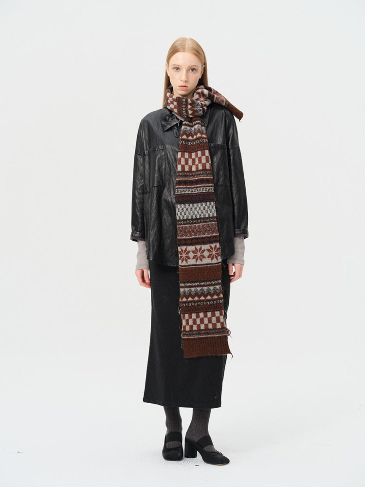 Woman wearing a black jacket and long skirt with a patterned scarf