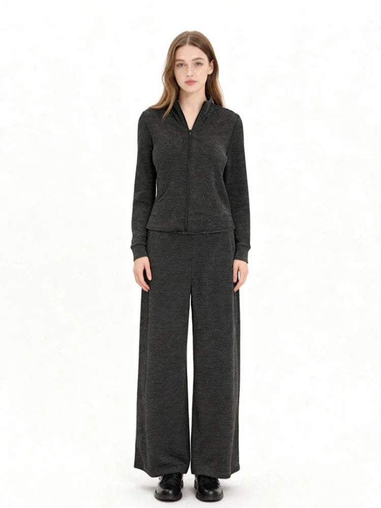 Woman wearing a charcoal grey knit loungewear set with a full zip jacket and wide leg pants, front view.