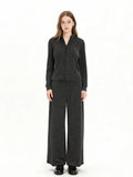 Woman wearing a charcoal grey knit loungewear set with a full zip jacket and wide leg pants, front view.