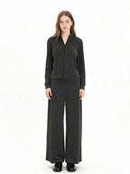 Woman wearing a charcoal grey knit loungewear set with a full zip jacket and wide leg pants, front view.