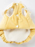 Inside view of a yellow pet vest showing button closures and fleece lining