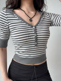 Close-up of a gray and white striped cropped knit top with short sleeves and a V-neck henley button detail