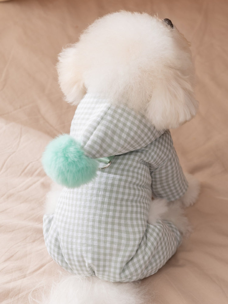 Rear view of a white Bichon Frise dog wearing a light green gingham hooded jumpsuit with a light green pom-pom