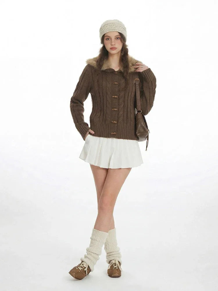 Front view of a woman in a brown knit cardigan with a fur collar.