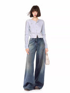 Woman wearing a light blue knit cardigan and wide-leg jeans.