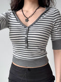 Front view of a woman in a striped cropped knit top and black skirt