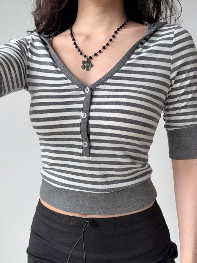 Front view of a woman in a striped cropped knit top and black skirt