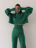 Front view of a woman in a green knit set, showcasing the high-waisted pants and cropped turtleneck top.