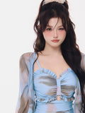 Close-up of a woman's chest area showing the blue abstract print and ruffled neckline of the dress