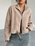 Woman wearing a beige corduroy cropped jacket with a stand collar and full zip closure.