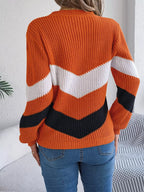 Back view of a woman in an orange, white, and black chevron stripe knit sweater
