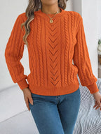Close-up of the textured knit pattern on an orange sweater worn by a woman.