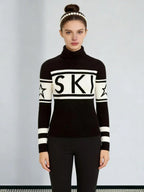 Woman wearing a black and white knit turtleneck sweater with 'SKI' graphic and star details