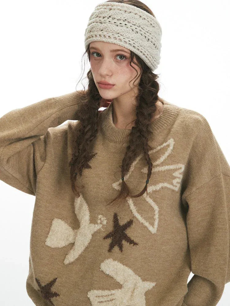 Close-up of the intarsia knit pattern on a tan sweater featuring birds and stars.