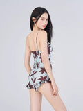 Rear view of a woman in a floral print romper swimsuit showing ruffled trim