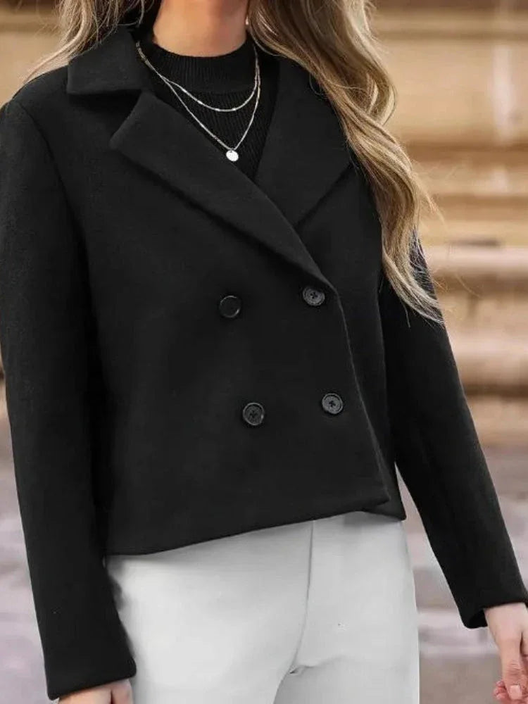 Close-up of the lapel and button detail on a black women's jacket.