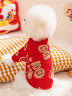 Back view of a small white dog wearing a red knit sweater with Chinese characters