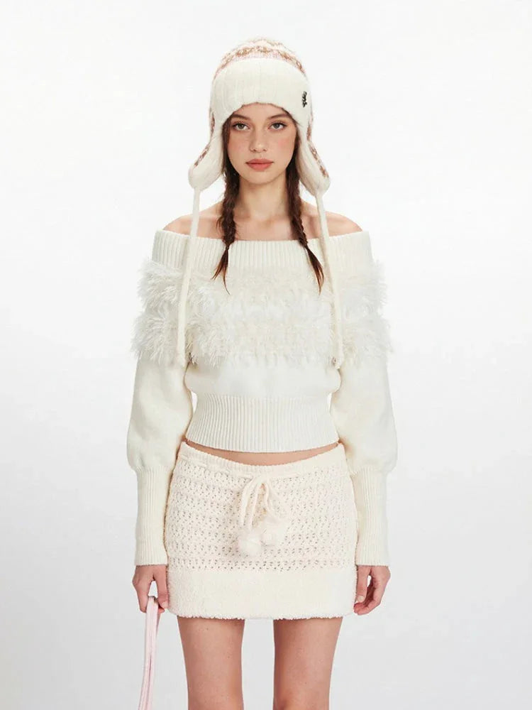 Close-up of a woman in a white off-the-shoulder sweater with fuzzy detailing.