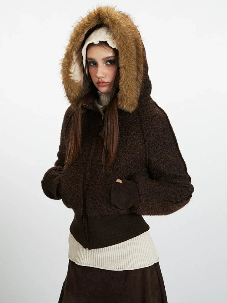 Model wearing a brown textured bomber jacket with a faux fur trimmed hood pulled up