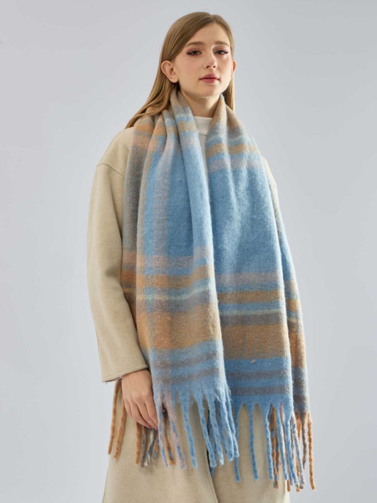 woman standing with a blue and tan plaid scarf draped around her