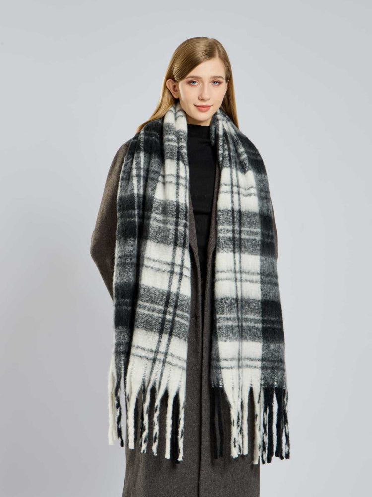 Woman wearing a black and white plaid scarf with fringe detail